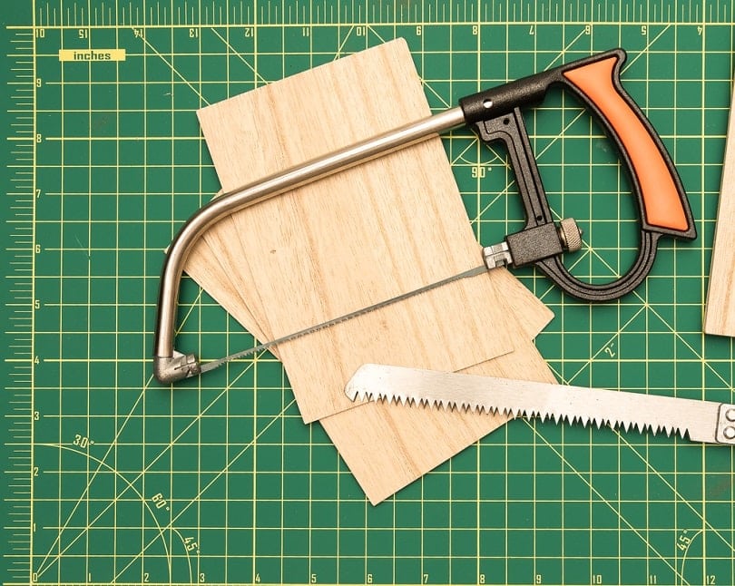 Wood saw on green cutting board with balsa wood_Zenith Pictures_shutterstock