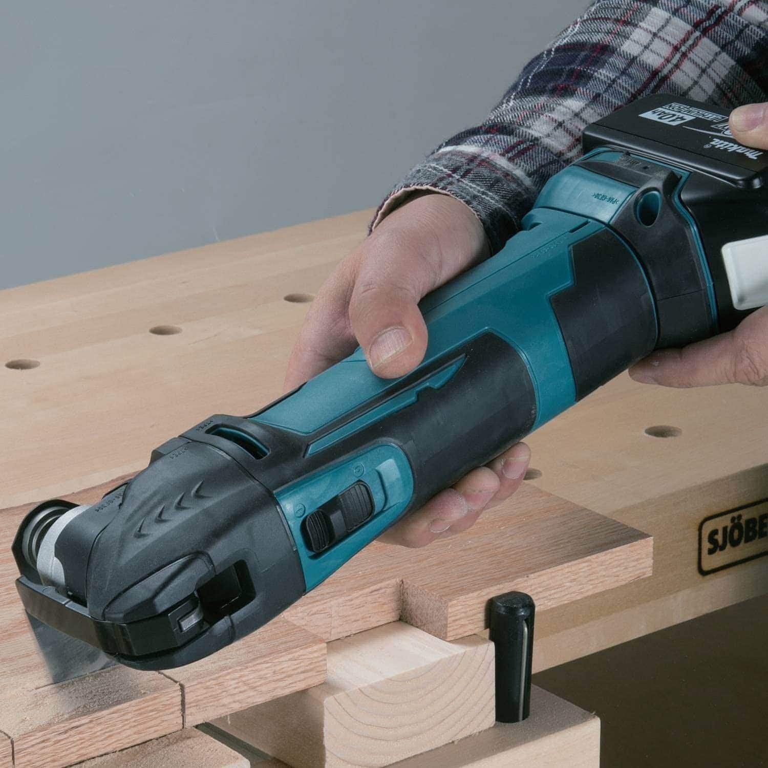 person using Makita XMT03Z Cordless Oscillating Tool