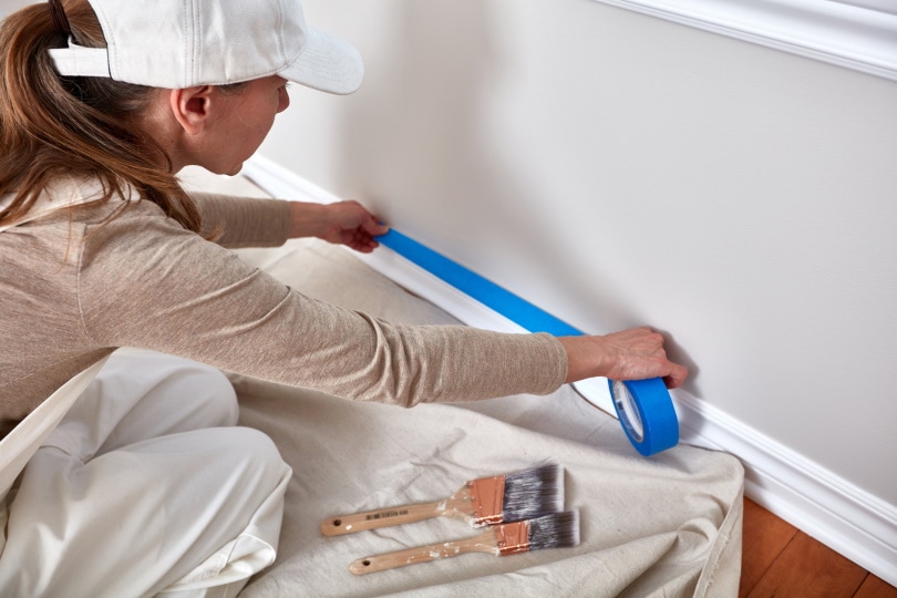 mujer pintando pared
