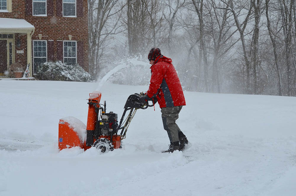 man using a snow blower