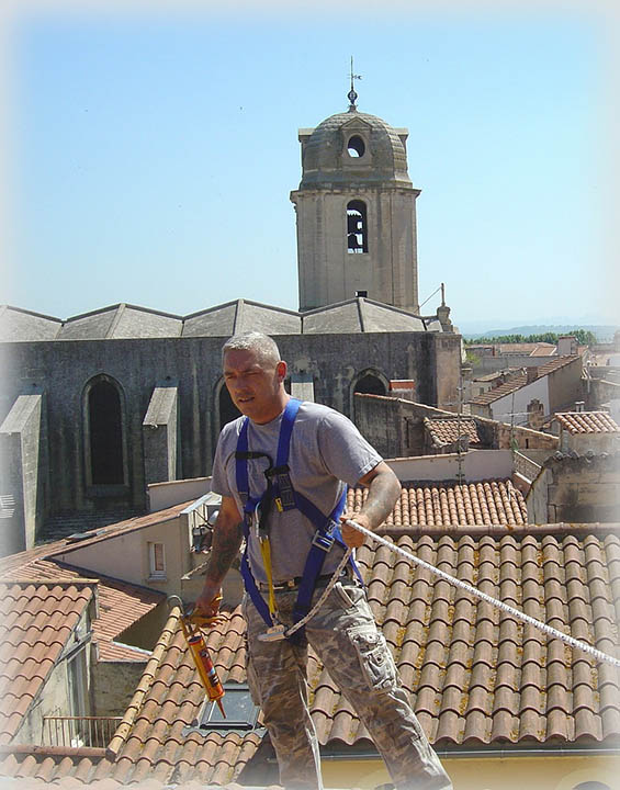 man with harness on top of the roof