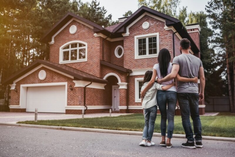family standing infront of a new house