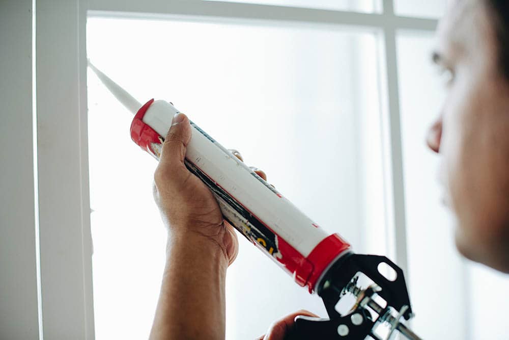 man glueing the window