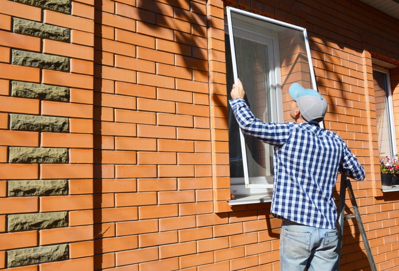 man installing window screen