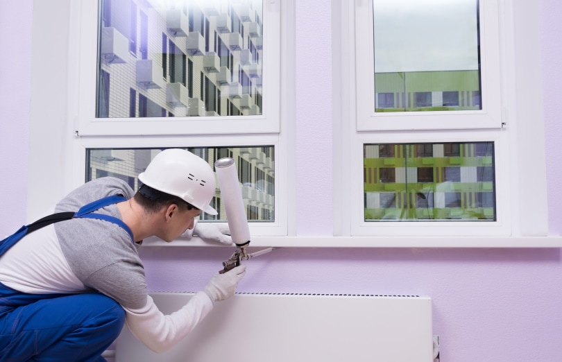 man insulates the window