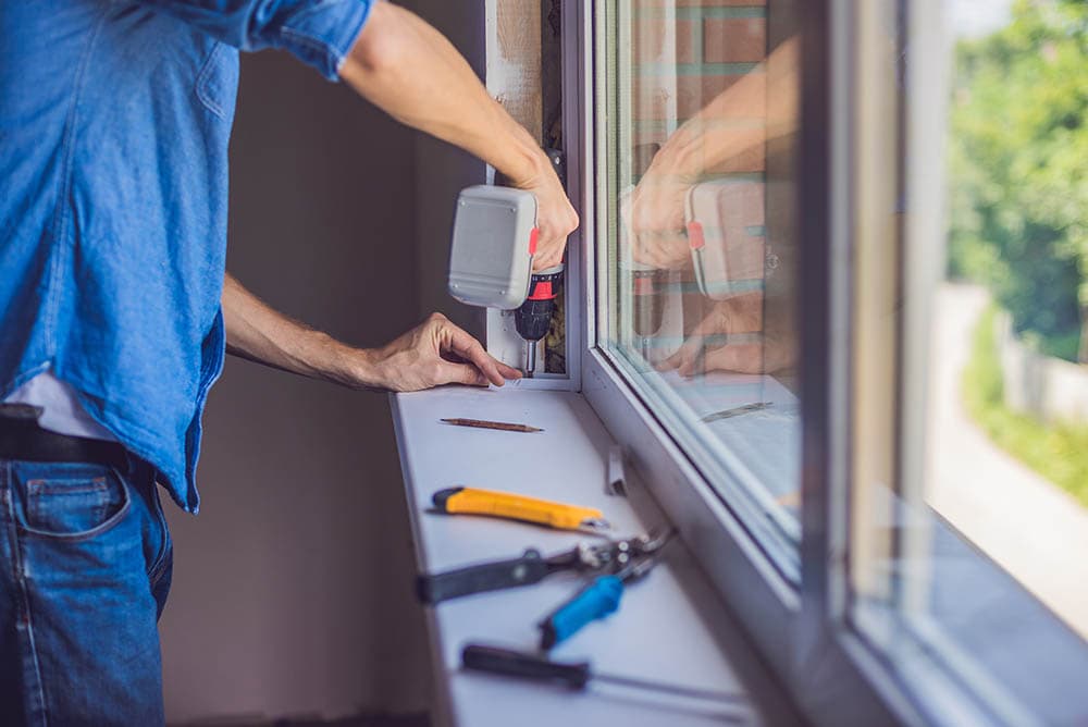 man repairing window