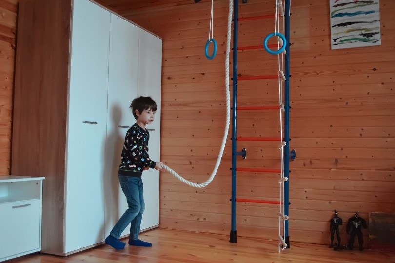 niño jugando juegos de cuerda en su habitación