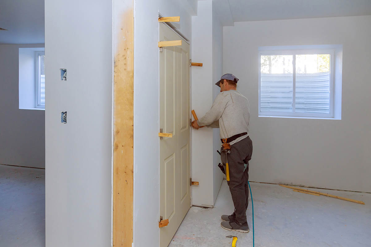 man installing interior door
