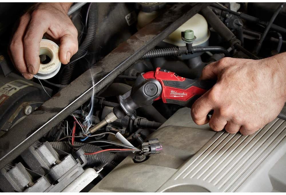 person using Milwaukee 2488-20 M12 Cordless Soldering Iron on his car