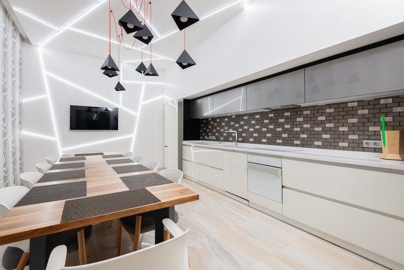 spacious light kitchen with dining table and modern furniture