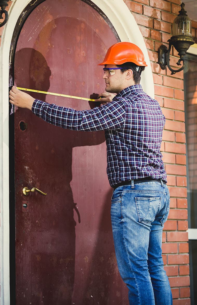 young man measuring exterior door