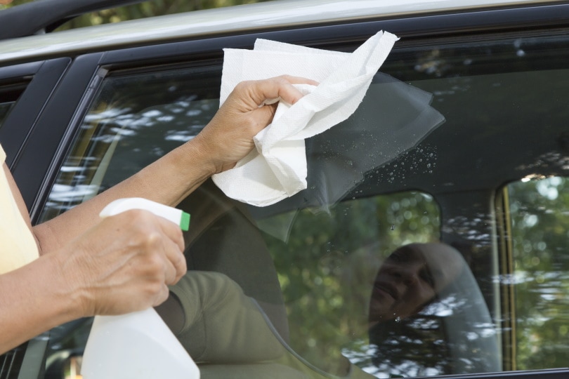 cleaning car window with paper towel