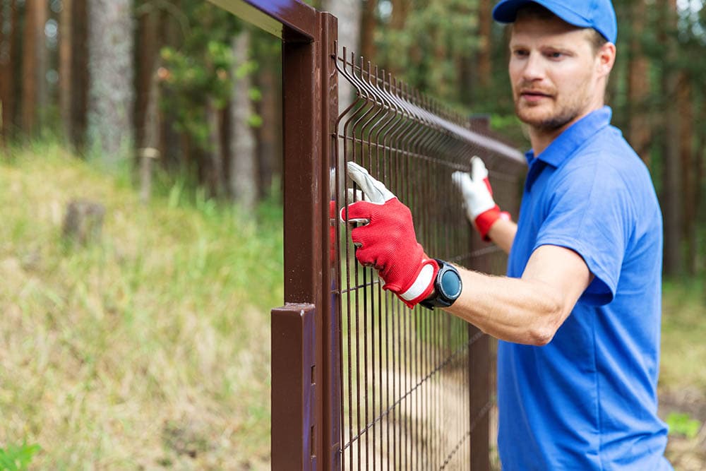 Man Installing Steel Fence Ronstik Shutterstock 