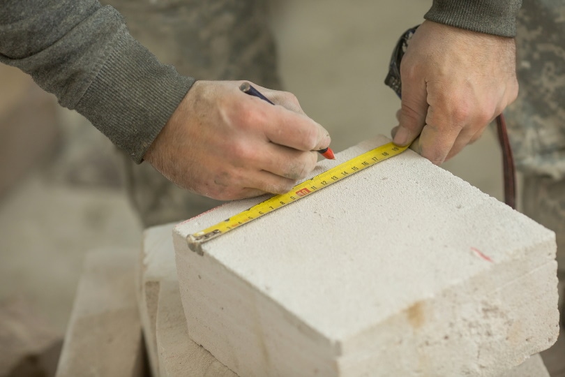 man measuring block