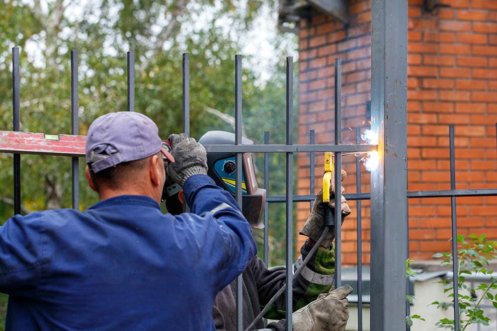 Two Professionals Installing Metal Fence Sergii Petruk Shutterstock 