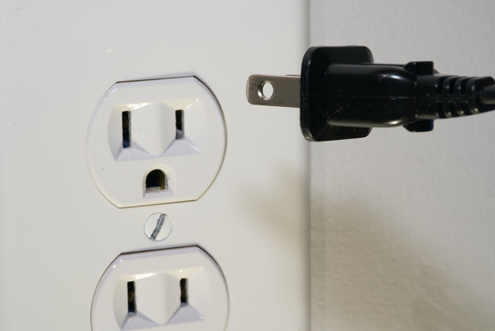 close up plugging in a cord to the outlet