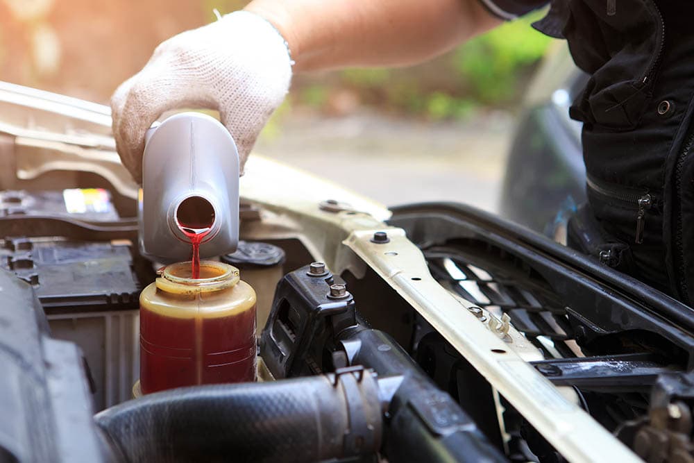 man filling car with new power steering fluid