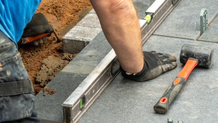 man installing bricks edging in the garden