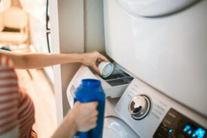 Person pouring liquid in the washing machine