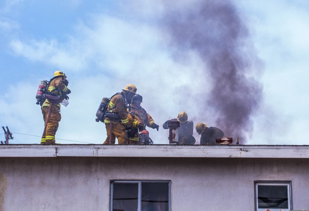 Smoking roof with fire fighters