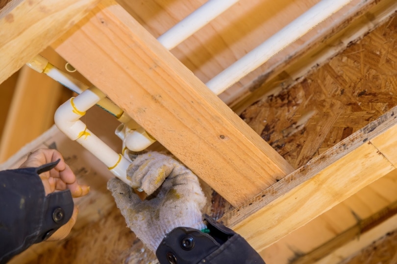 plumber working on water pipes