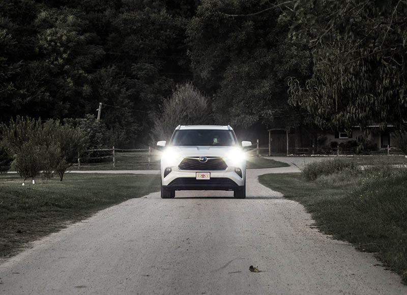 white toyota highlander in the middle of the road