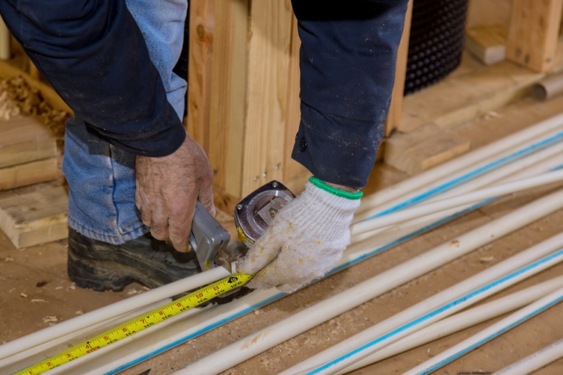worker cutting CPVC pipe