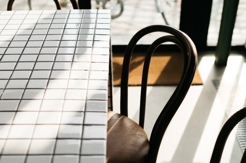 a white rectangular tiled table with chairs