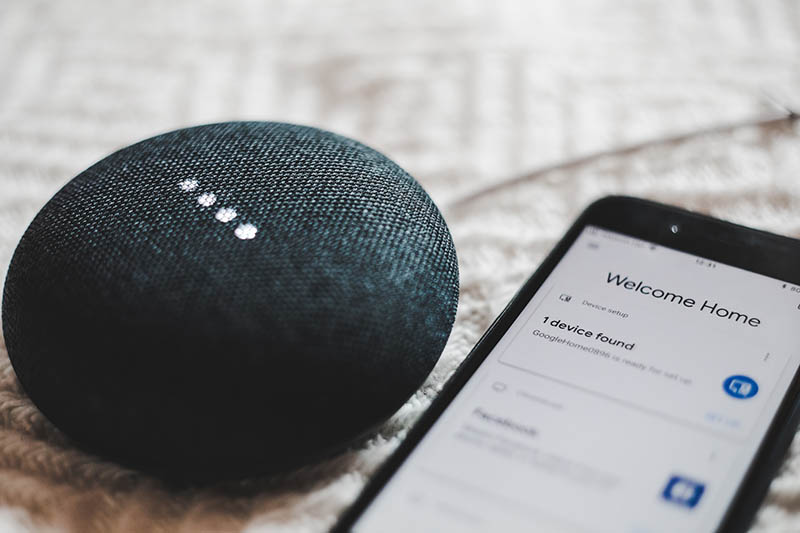 google home speaker beside a smartphone
