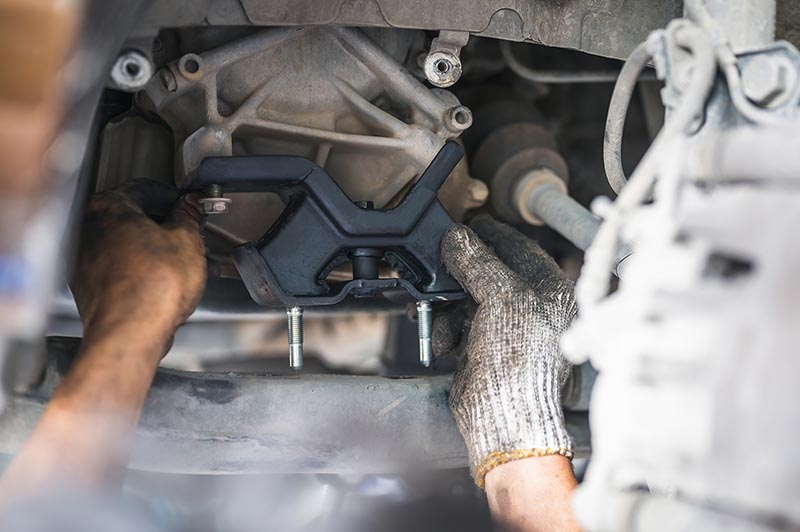 mechanic installing engine mount