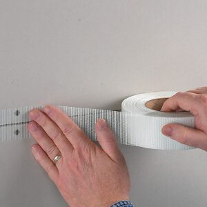 person applying FibaTape FDW8654-U Perfect Finish, Ultra-Thin Joint Drywall Tape on the wall