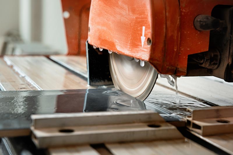 wet saw cuts through a ceramic tile