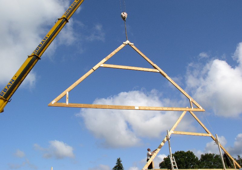wooden roof trusses against a blue sky background