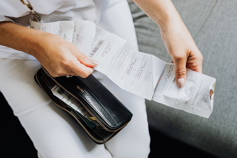 A Person Holding a Wallet and a Receipt