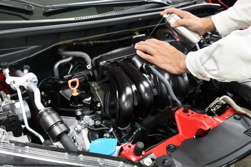 Car engine room under maintenance putting degreaser