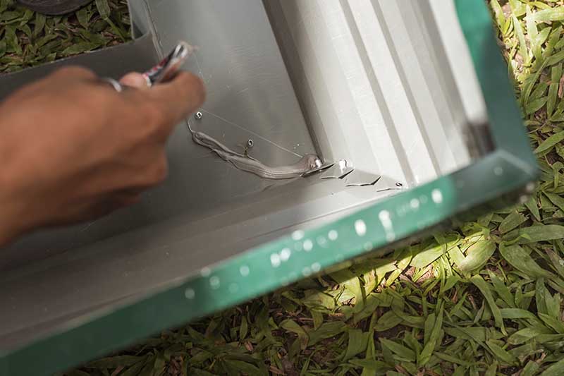 Using metal epoxy to seal the joints between two pieces of gutter