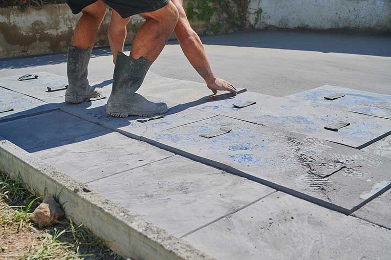 Worker placing mold on printed concrete