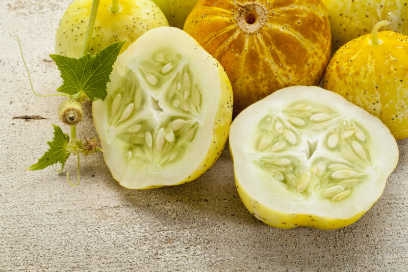 lemon (or apple) cucumbers on rough white painted wood surface