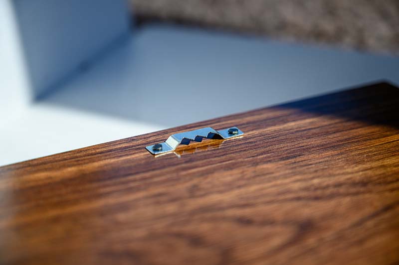 Saw tooth wall hanging hardware on walnut wood