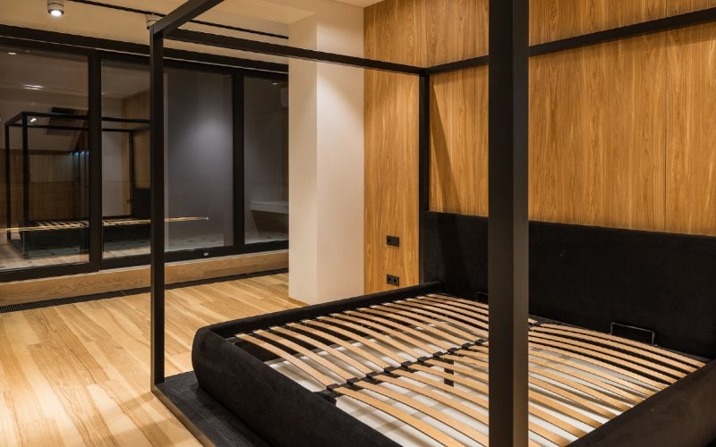 black four-poster bed frame without mattress