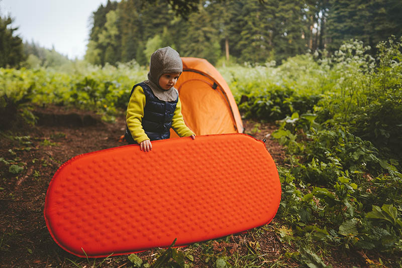 child holding the sleeping pad
