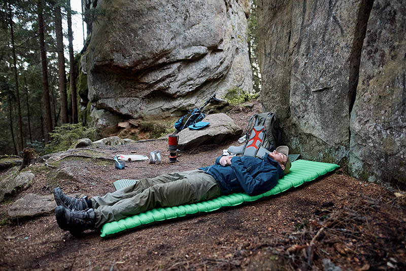 man sleeping on sleeping pad in the woods