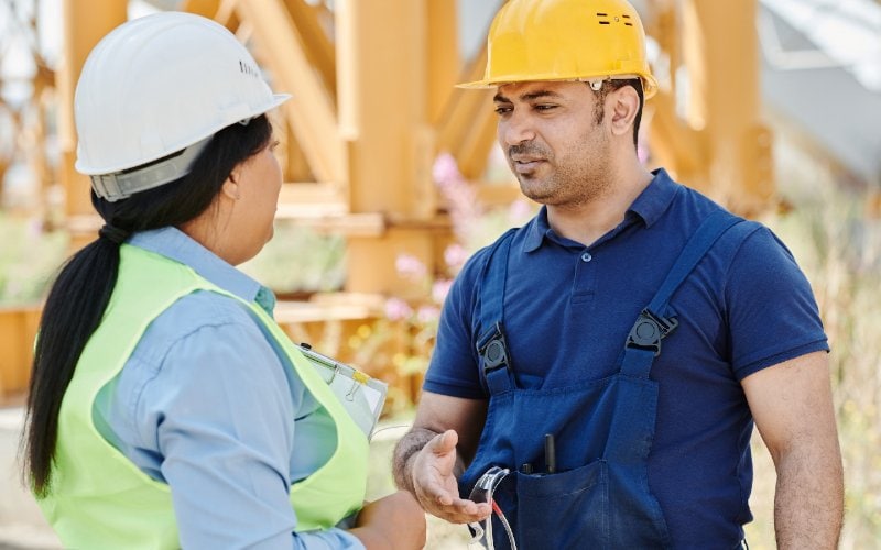 man talking to a woman at a construction site
