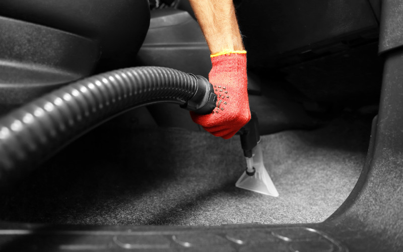 person using a vacuum in a car