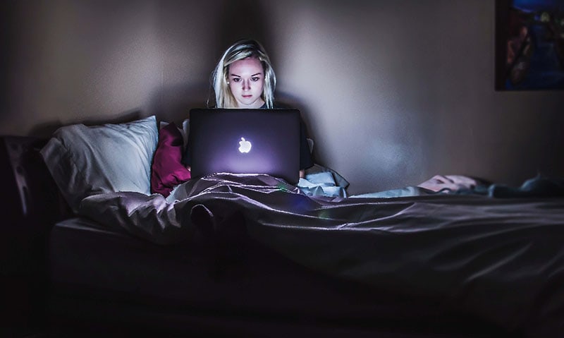 woman using her laptop in bed