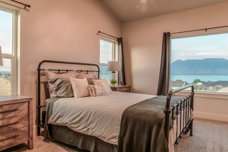 Metal frame double bed inside bedroom with view of the lake and neighborhood
