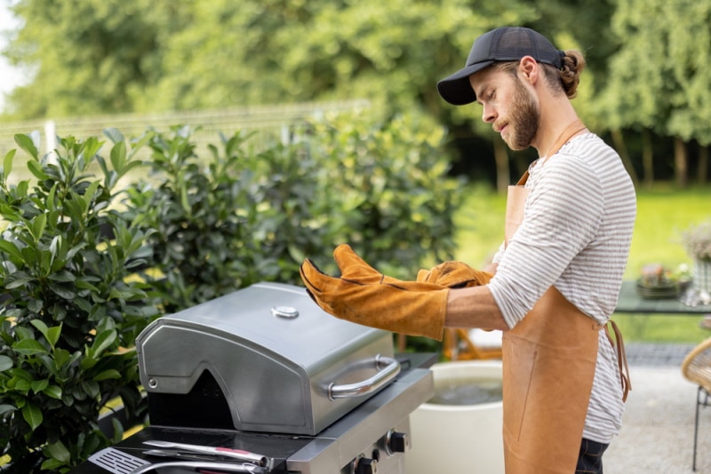man using BBQ gloves