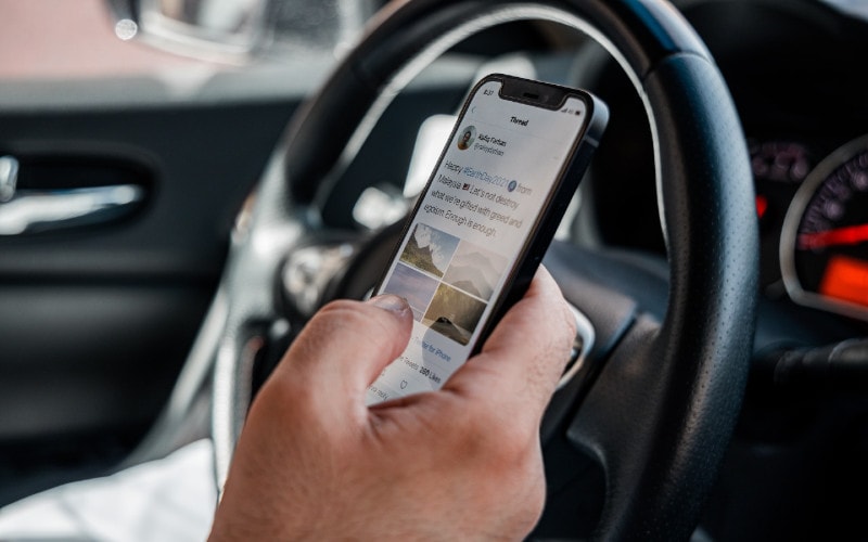 person using their phone while driving a car
