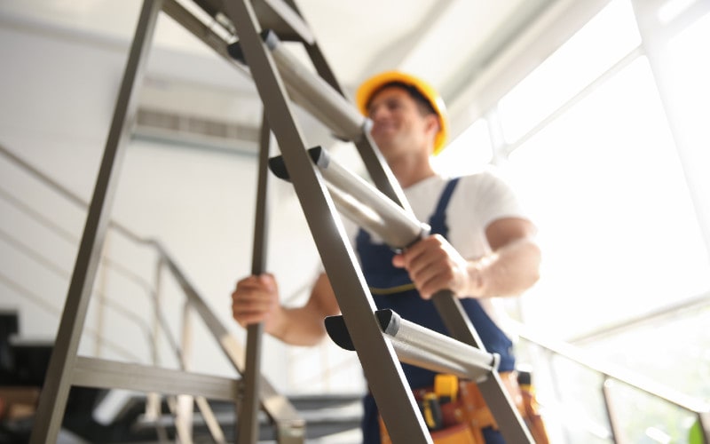 professional builder holding a construction ladder