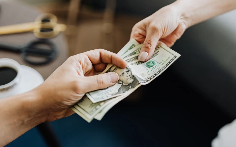 two people exchanging money in dollar currency